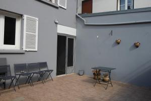 a patio with four tables and chairs and a building at La Chandeler in Juvigny-sous-Andaine
