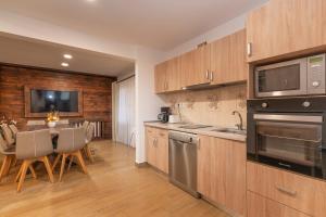 a kitchen with wooden cabinets and a table with chairs at Villa Ecaterina in Poiana Negrii