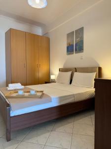 a bedroom with a large bed with wooden cabinets at EverBlue Suites - Halkidiki Beachfront in Psakoudia