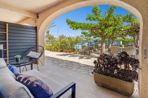 an outdoor patio with a couch and a tree at Hôtel La Nartelle in Sainte-Maxime