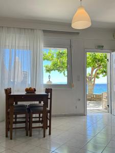 a dining room with a table and a view of the ocean at EverBlue Suites - Halkidiki Beachfront in Psakoudia