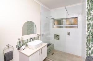 a white bathroom with a sink and a shower at 36 Alexander Guesthouse,Highlands,Harare in Highlands