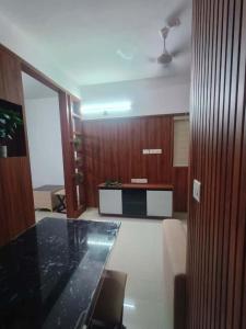 a living room with a table and a kitchen at Kalpaka lee divine in Guruvāyūr