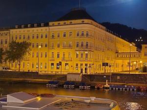 a large yellow building next to a river at night at FERIENWOHNUNG Marina in Bad Ems