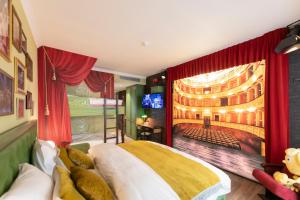 a bedroom with a large bed and a large screen at Plopsaland Theater Hotel in De Panne