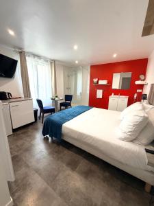 a bedroom with a large bed and a red wall at Aux Charmes - Suites Prestige et Petit Déjeuner en chambre - Cote d Opale in Isques