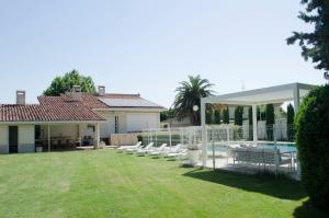 a yard with a group of white chairs and a pool at Casa rural Villa Verde in Tudela