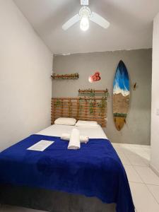 a bedroom with a blue bed with towels on it at Pousada Praia do Tombo in Guarujá
