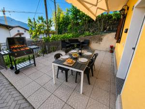 a table and chairs on a patio with a grill at Casa Sophie in Consiglio di Rumo