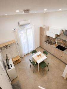 a room with a table and chairs and a kitchen at Bukowski Loft House in Porticello