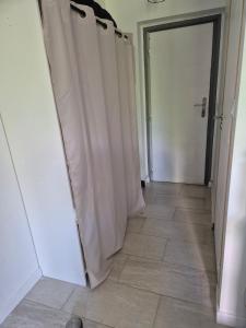 a hallway with white curtains and a door at Studio centre-clim-parking privée-rdc in Saint-Gaudens