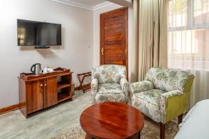 a living room with a chair and a table at 36 Alexander Guesthouse,Highlands,Harare in Highlands