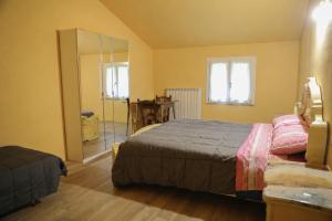 a bedroom with a bed and a mirror at Cusna Rooms in Febbio