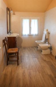 a bathroom with a toilet and a sink at Cusna Rooms in Febbio