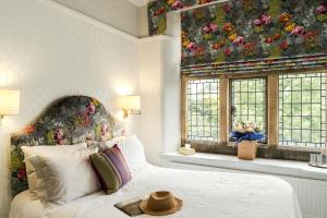 a bedroom with a bed with a flower mural on the wall at Fischers Baslow Hall - Chatsworth in Baslow