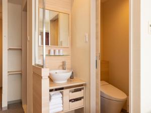 a small bathroom with a toilet and a sink at Hotel Keihan Kyobashi Grande in Osaka