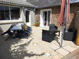 a patio with a table and chairs and a grill at L'Escale in Pendé