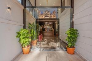 a hallway with potted plants in front of a building at Hotel Zillion International Near US Consulate B K C Mumbai Near Mumbai Airport Mumbai in Mumbai