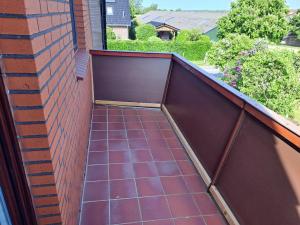 a balcony with a tile floor and a brick wall at FeWo Petersen, Köhn in KÃ¶hn