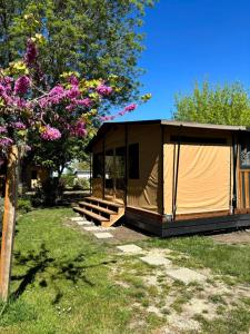 a large tent in a yard with a tree at Camping Onlycamp les Cochards in Seigy