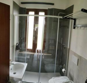 a bathroom with a shower and a toilet and a sink at Casa di zio in Monticiano