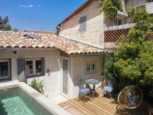a patio with a table and chairs next to a house at Casa d'Olivier chambre d'hôtes in Arles