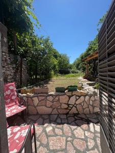 a stone wall with a table and a chair on a patio at Old street 2 in Podgorica
