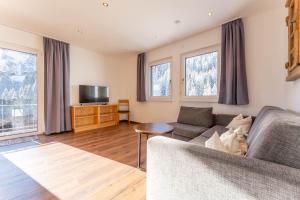 a living room with a couch and a television at Elisabeth Appartements in Damuls
