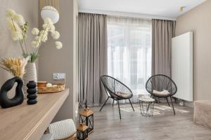 a living room with two chairs and a table at Perfect Holiday Apartments Bel Mare by Noclegi Renters in Międzyzdroje