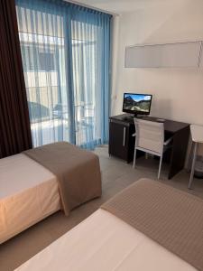 una camera da letto con un letto e una scrivania con un computer di Residence Ormeggio a Grado
