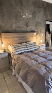 a bed in a bedroom with a chalkboard on the wall at Calma in Miramar