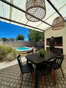 a patio with a black table and chairs and a pool at Calma in Miramar