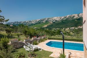 a swimming pool with a view of a mountain at Apartments Bavaria in Baška
