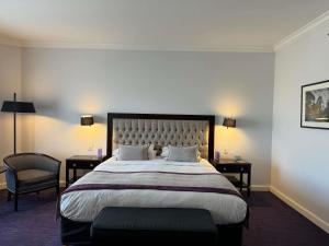 a bedroom with a large bed with two tables and a chair at Sofitel Buenos Aires Recoleta in Buenos Aires +169 photos