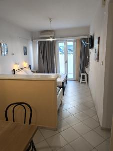 a room with a bed and a table and a bedroom at Renia Studios - Pool & Beach in 150m - Agia Pelagia in Agia Pelagia