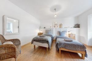 a bedroom with two beds and a chair at Ti Illiz in Le Conquet