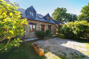 a brick house with a yard in front of it at La Poya in Plonévez-du-Faou