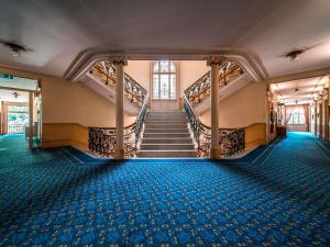 a staircase in a building with blue carpet at Royal St. Georges Hotel Interlaken - MGallery Collection in Interlaken