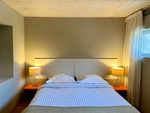 a bedroom with a bed with two lamps on two tables at Les Foucauds in Saint-Quentin-de-Caplong