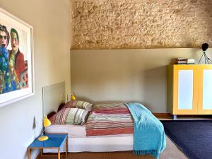 a bedroom with a bed and a painting on the wall at Les Foucauds in Saint-Quentin-de-Caplong
