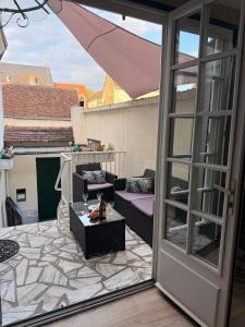 a patio with a couch and a table on a balcony at Gîte Du Centre avec terrasse in Romorantin