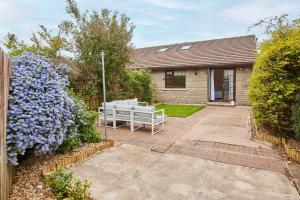 a house with a garden with purple flowers at Host & Stay - Puffin Cove in Seahouses