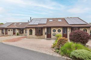 a house with solar panels on the roof at Host & Stay - Puffin Cove in Seahouses