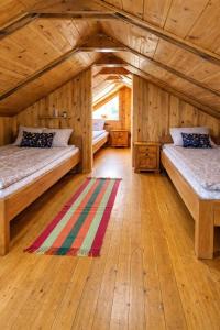 two beds in a room with a wooden ceiling at Drinska Villa Cabin in Perućac