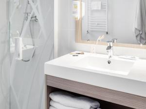 a bathroom with a white sink and a shower at Aparthotel Adagio Access Paris Clichy in Clichy +51 photos