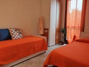 a bedroom with two beds and a window at Cherry House: Giardino Privato & Relax vicino Pisa in Ponsacco