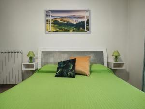 a green bed with two pillows on top of it at Cherry House: Giardino Privato & Relax vicino Pisa in Ponsacco +13 photos