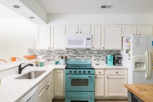 a kitchen with a blue stove and a microwave at Pool & Spa Game Rm Walking Distance to Beach & Shops in Duck
