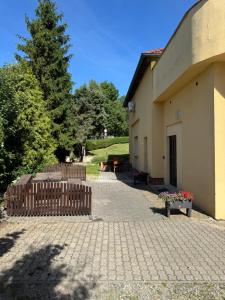 a building with a bench next to a tree at Apartmány Veronika - Blansko in Blansko