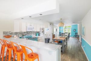 a kitchen with white cabinets and orange chairs at Pool & Spa Game Rm Walking Distance to Beach & Shops in Duck +66 photos